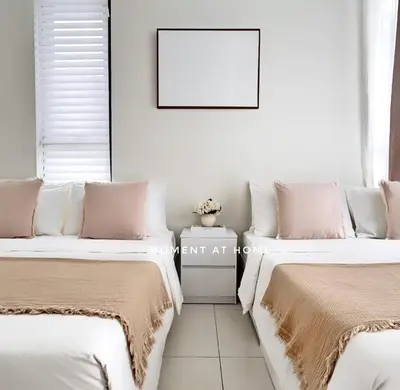 two beds sitting next to each other in a room at The Urban Suites City&seaview in Jelutong
