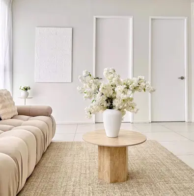 a living room with a vase of flowers on a table at The Urban Suites City&seaview in Jelutong