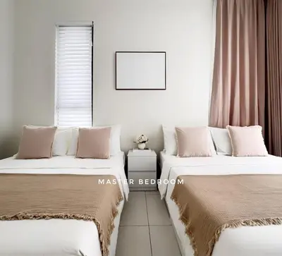 two beds sitting next to each other in a bedroom at The Urban Suites City&seaview in Jelutong