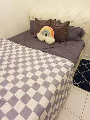 a bed with a comforter with a rainbow on it at AR Homestay SP TRJ in Sungai Petani