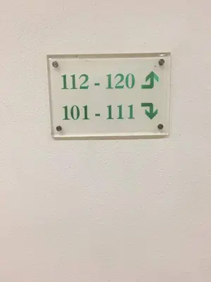 a sign on a wall with a clock on it at Harbour View Hotel Sekinchan in Sekincan