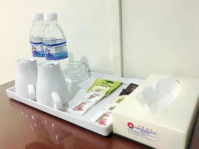 a tray with cups and milk bottles on a table at Harbour View Hotel Sekinchan in Sekincan