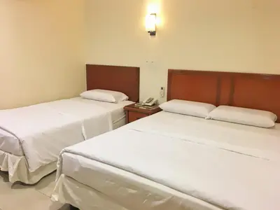 two beds in a hotel room with a phone at Harbour View Hotel Sekinchan in Sekincan