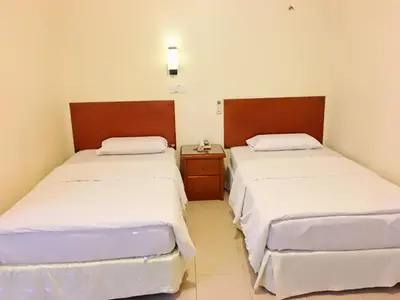two beds in a small room with at Harbour View Hotel Sekinchan in Sekincan
