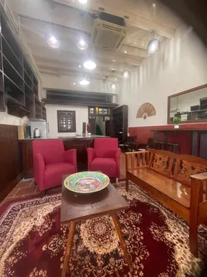 a living room with red chairs and a table at Pearl Heritage Homestay in George Town