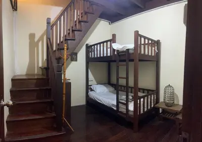 a room with two bunk beds and a staircase at Pearl Heritage Homestay in George Town