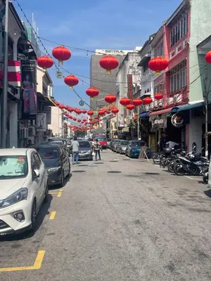 a street with red umbrellas hanging over a street at Pearl Heritage Homestay in George Town
