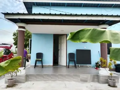 a blue house with two chairs and a porch at Aziyaa homestay rumah no2 in Sungai Besar