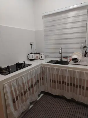 a kitchen counter with a sink and a window at Risfeena Home in Sekincan