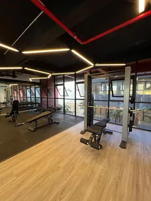 a gym with treadmills and a table and chairs at Modern Two Bedroom Ipoh City Apartment with Pool, Gym and Free Parking in Ipoh