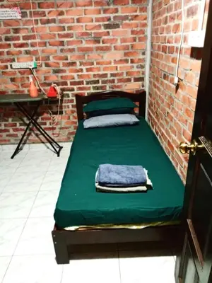 a bed in a room with a brick wall at Homestay Anjang in Tapah