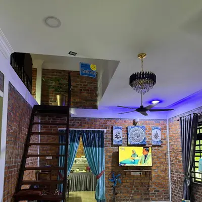 a living room with a brick wall and a tv at Homestay Anjang in Tapah