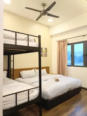 two bunk beds in a room with a ceiling fan at Bayt Rizq Homestay 3R2B in Brinchang