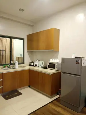a kitchen with wooden cabinets and a stainless steel refrigerator at Bayt Rizq Homestay 3R2B in Brinchang