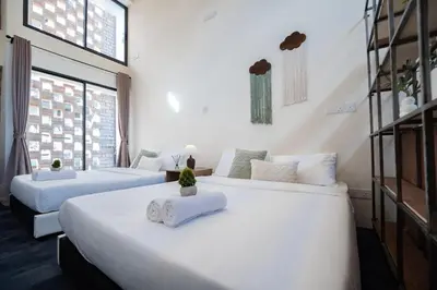 two large beds in a room with white walls at Georgetown Heritage 1F stay 10pax 3BR in George Town