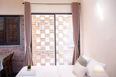 a bedroom with a window with a brick wall at Georgetown Heritage 1F stay 10pax 3BR in George Town