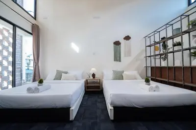 two beds in a room with white walls and windows at Georgetown Heritage 1F stay 10pax 3BR in George Town