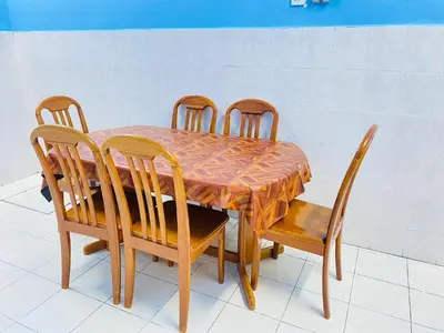 a wooden table with four chairs and a table and a table and chairsktop at Homestay Sayang in Ipoh