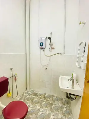a bathroom with a shower and a toilet and a sink at Homestay Sayang in Ipoh