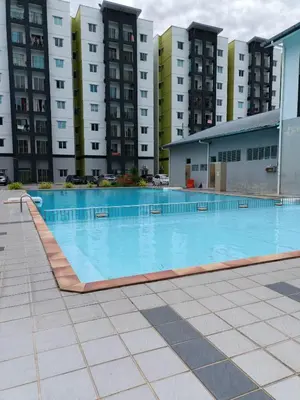 an empty swimming pool in front of tall buildings at Seri Homestay Apartment Seri Iskandar in Seri Iskandar