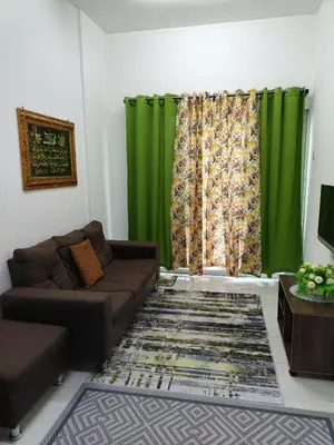 a living room with a couch and green curtains at Seri Homestay Apartment Seri Iskandar in Seri Iskandar
