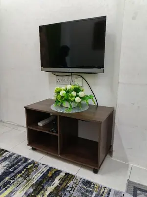 a tv sitting on top of a table with flowers on it at Seri Homestay Apartment Seri Iskandar in Seri Iskandar