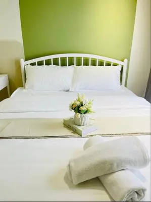 a white bed with a white blanket and flowers on it at The Horizon Ipoh by Amris in Ipoh