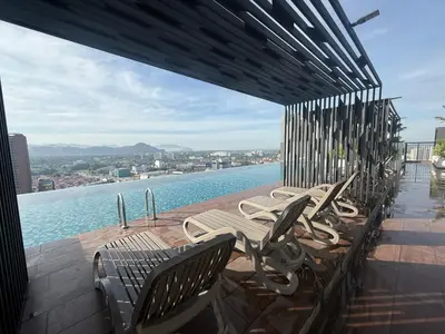 a row of chairs sitting on a deck overlooking the water at The Horizon Ipoh by Amris in Ipoh