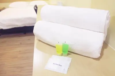 a hotel room with towels and two glasses on a table at No.31 Maple Inn in Simpang Ampat