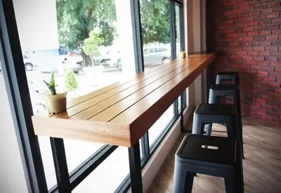 a bar in a room with a window and two stools at No.31 Maple Inn in Simpang Ampat