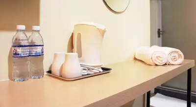 a counter with a blender and two bottles of water at No.31 Maple Inn in Simpang Ampat