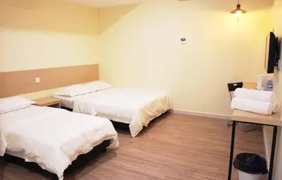 a hotel room with two beds and a desk at No.31 Maple Inn in Simpang Ampat