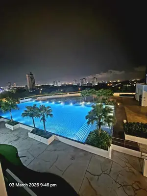 a large swimming pool with palm trees in a city at Marvel Nest- 3bedroom-Poolview-10pax in Bukit Mertajam