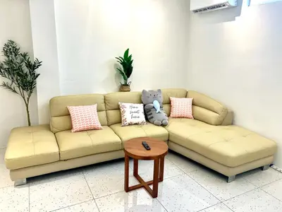 a living room with a couch with pillows and a table at Casa for 8 ipoh Central Pet Allowed in Ipoh