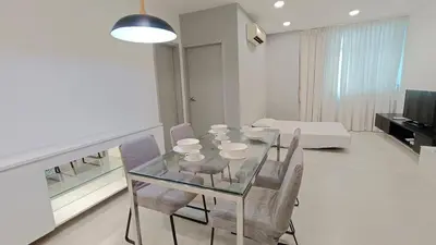 a dining room with a glass table and chairs at Straits Garden Penang 2BR in Jelutong