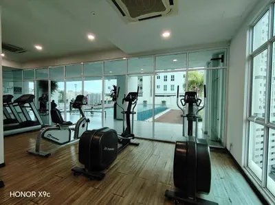 a gym with treadmills and ellipticals in a building at Straits Garden Penang 2BR in Jelutong