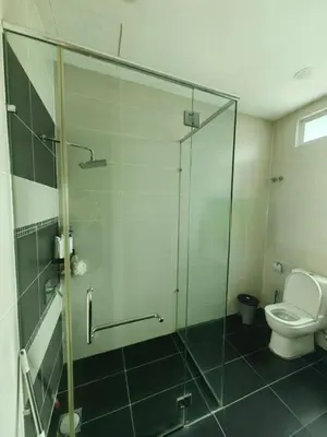 a bathroom with a glass shower and a toilet at Lakeside house in Gua Sai
