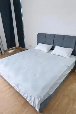 a large bed with white sheets and pillows on it at Lakeside house in Gua Sai
