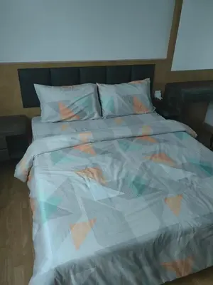 a bed with a colorful comforter and pillows at Lakeside house in Gua Sai