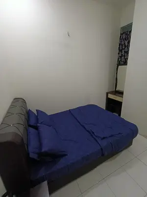 a bed with a blue blanket in a room at restu ibu homestay hillpark sp in Sungai Petani