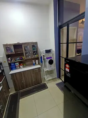 a kitchen with wooden cabinets and a treadmill in a room at restu ibu homestay hillpark sp in Sungai Petani