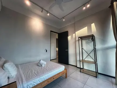 a bedroom with a bed and a ladder at Le Jardin Suite 8 Pax Sea View Infinity Pool in George Town