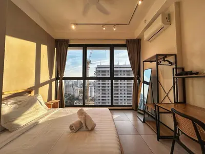 a bedroom with a bed and a desk and a large window at Le Jardin Suite 8 Pax Sea View Infinity Pool in George Town