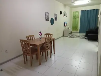 a dining room table and chairs in a living room at Hani Homestayz2U in Kuala Lipis