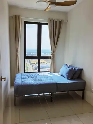 a bed in a room with a large window at Batu Kawan Sunset Seaview Condo near Ikea & Design Village in Batu Kawan