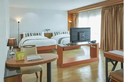 a hotel room with two beds and a television at Luna hotel in Gua Sai