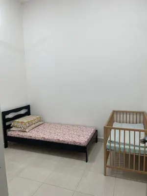 two beds in a room with a white wall at Nafisa Homestay in Kepala Batas