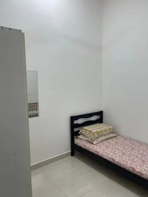 a bed in a room with a white wall at Nafisa Homestay in Kepala Batas