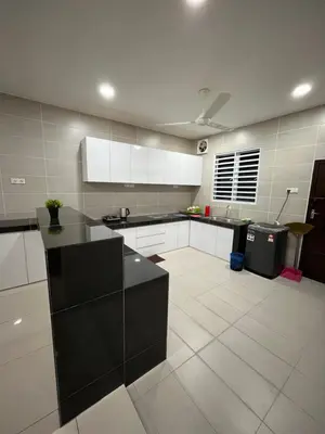 a large kitchen with white cabinets and black counter tops at KK Homestay Ipoh in Ipoh