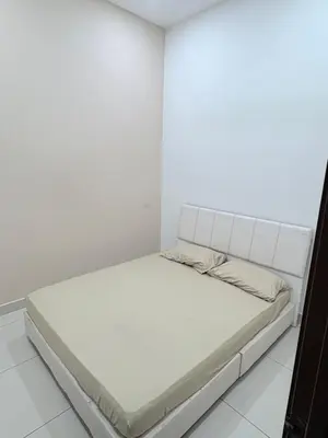a bed in a room with a white wall at KK Homestay Ipoh in Ipoh